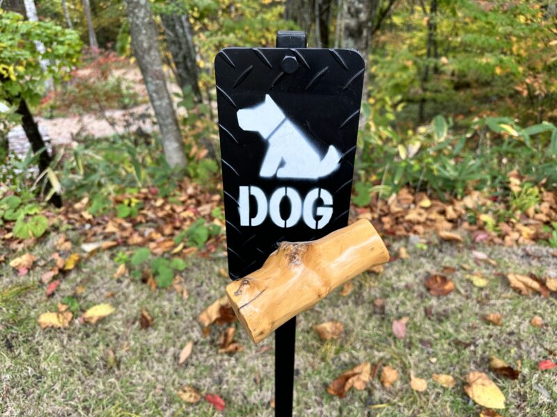 しらかば平駅周辺の散策路に立つ犬マークの「DOG」看板と落ち葉
